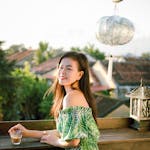 Young woman enjoying a sunny afternoon on a stylish balcony in Hội An, Vietnam.